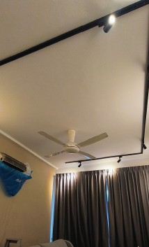 Wall-mounted air-conditioner fitted with a blue chemical wash containment bag under track lighting